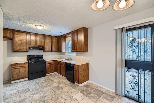 kitchen with under cabinet range hood, a sink, light countertops, black appliances, and brown cabinetry