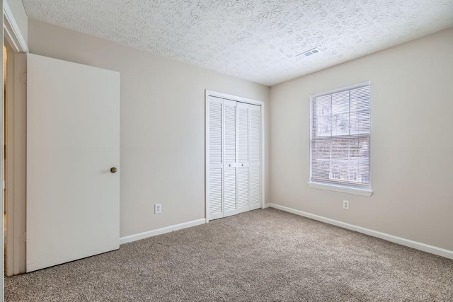 unfurnished bedroom with carpet, baseboards, and a closet