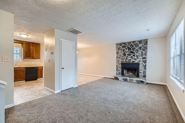 unfurnished living room featuring a wealth of natural light, light colored carpet, visible vents, and a fireplace