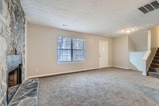 unfurnished living room with visible vents, a fireplace, stairway, and carpet flooring