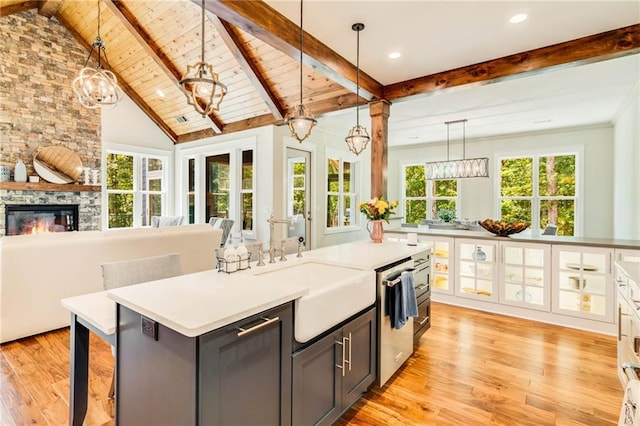 kitchen featuring pendant lighting, sink, a breakfast bar, a kitchen island, and stainless steel dishwasher