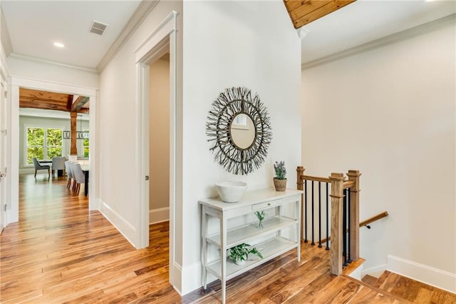 corridor featuring ornamental molding and light hardwood / wood-style floors