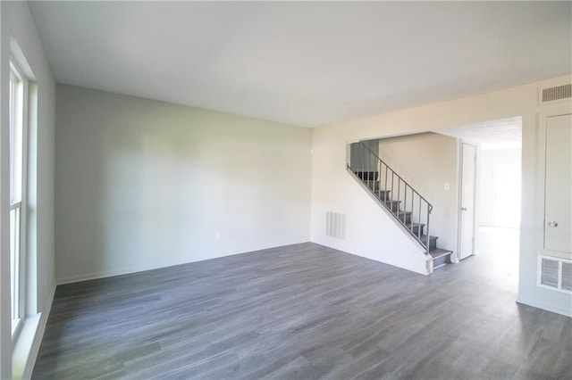 unfurnished room featuring a wealth of natural light and dark wood-type flooring