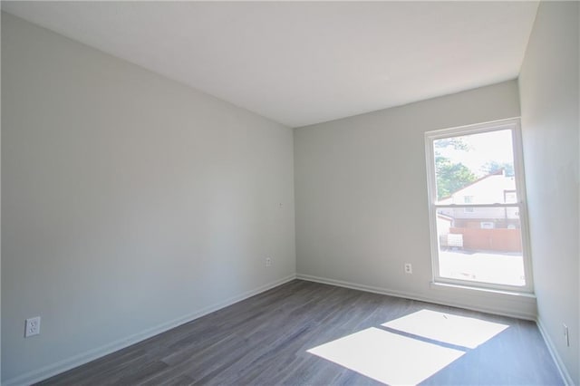 unfurnished room with dark hardwood / wood-style flooring