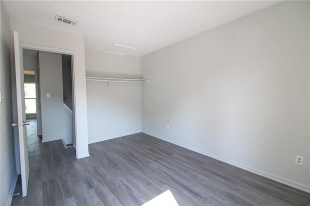 unfurnished bedroom featuring a closet and dark wood-type flooring