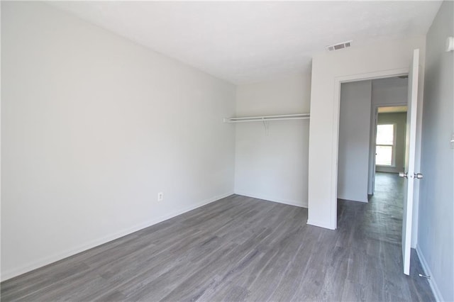 unfurnished bedroom with a closet and dark wood-type flooring