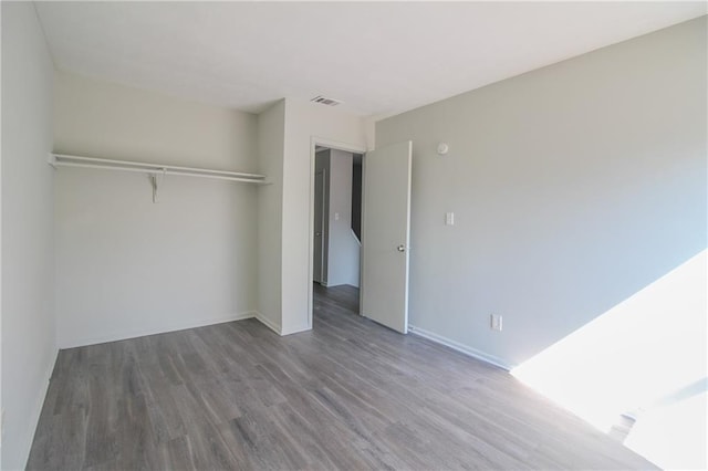 unfurnished bedroom featuring hardwood / wood-style flooring and a closet