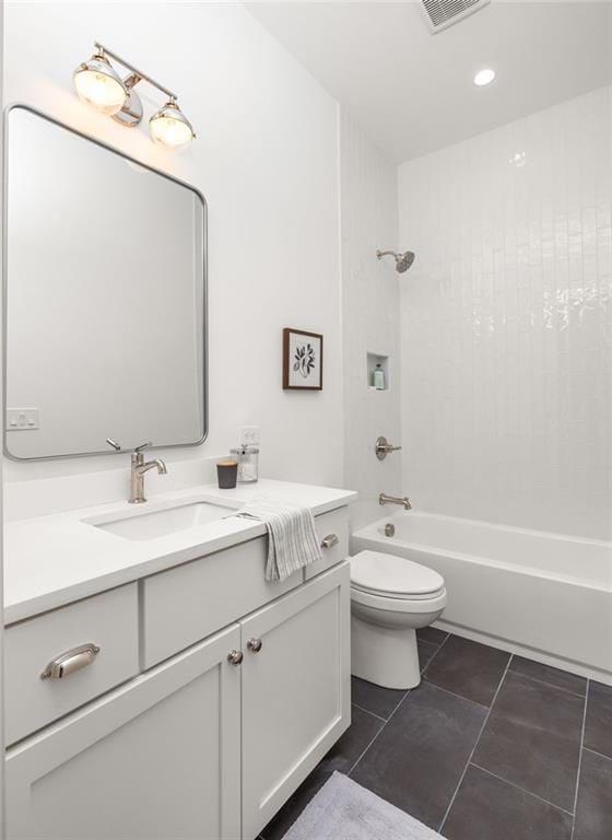 full bathroom with tiled shower / bath, tile patterned floors, toilet, and vanity