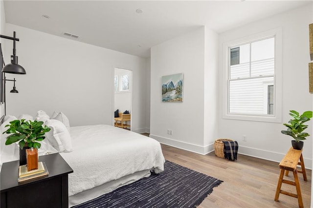 bedroom featuring hardwood / wood-style flooring and multiple windows