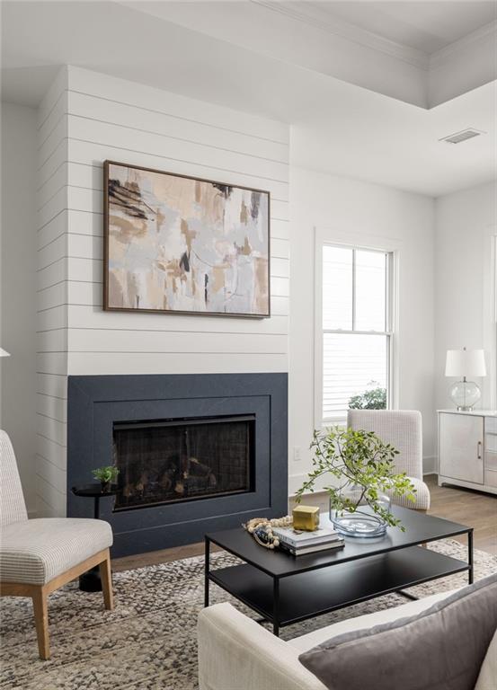 living room featuring hardwood / wood-style flooring and crown molding