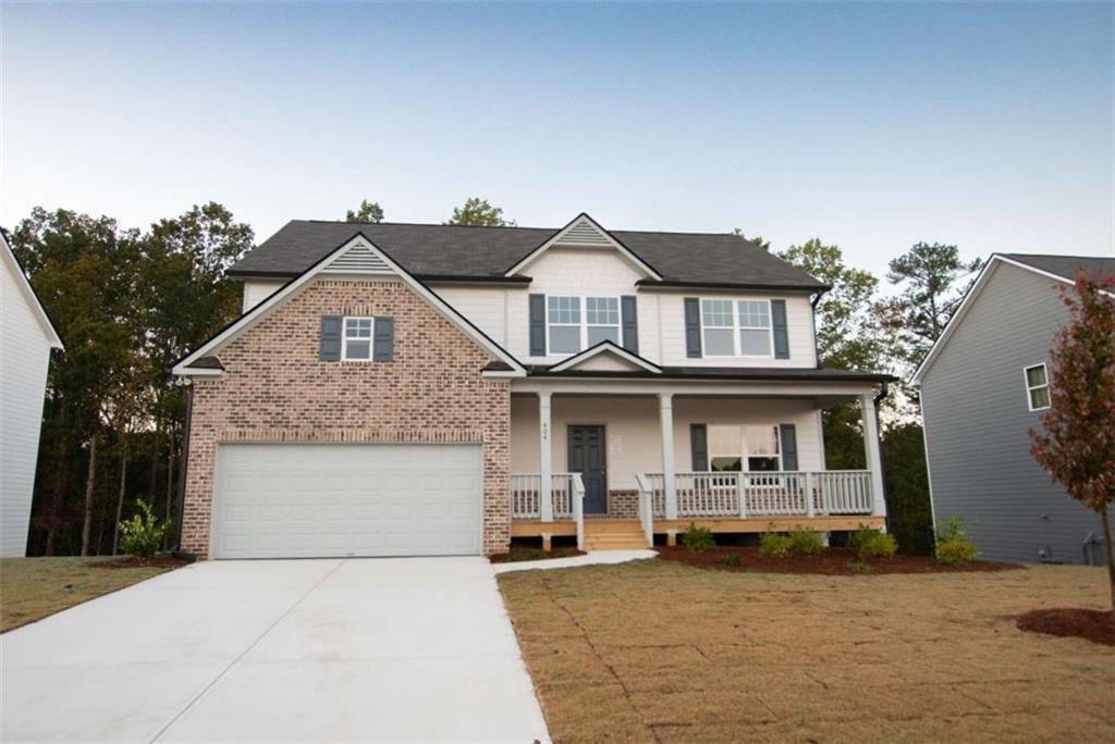 view of front facade with a front lawn, a porch, and a garage