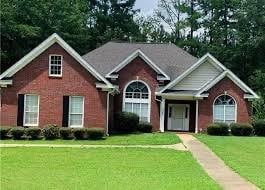 view of front facade featuring brick siding and a front lawn