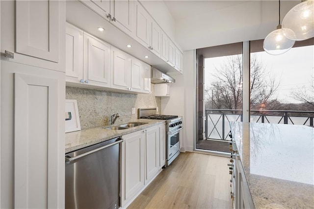 kitchen with white cabinetry, hanging light fixtures, light stone countertops, and appliances with stainless steel finishes