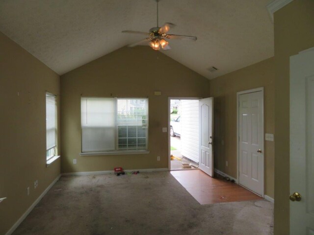 unfurnished room featuring ceiling fan, high vaulted ceiling, a wealth of natural light, and carpet