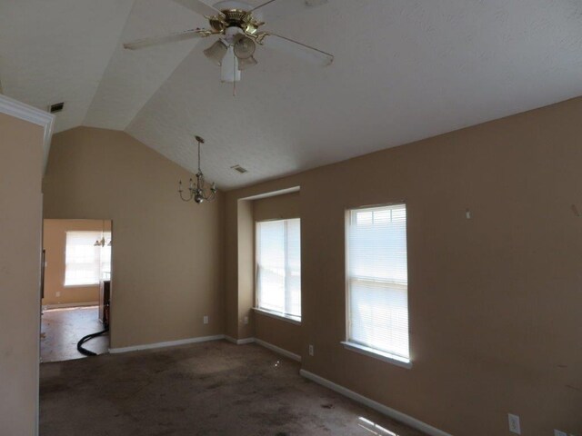 interior space with vaulted ceiling, ceiling fan with notable chandelier, a healthy amount of sunlight, and carpet