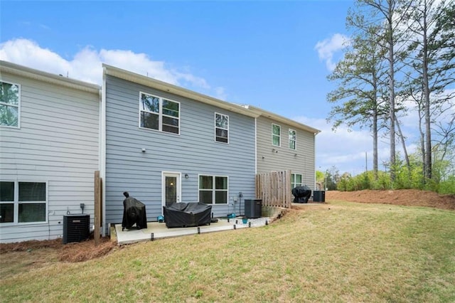 rear view of property featuring central AC unit, a yard, and a patio
