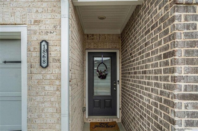 property entrance featuring brick siding