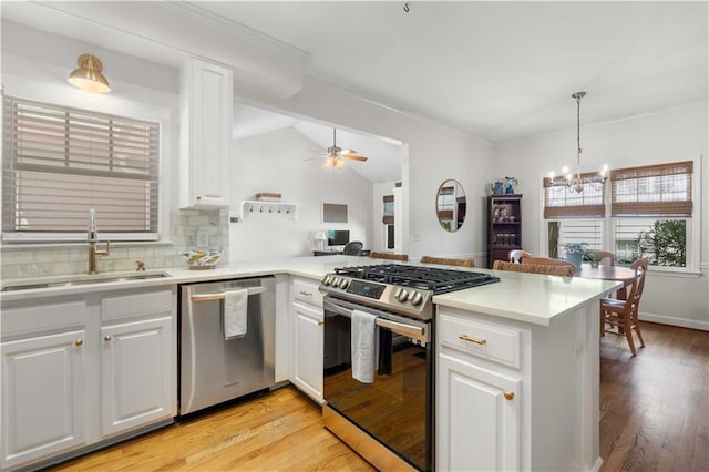 kitchen featuring appliances with stainless steel finishes, light hardwood / wood-style flooring, sink, white cabinetry, and kitchen peninsula