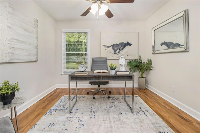 office space with wood finished floors, a ceiling fan, and baseboards