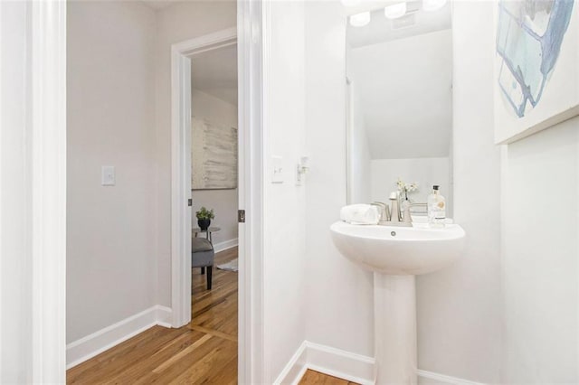 bathroom with wood finished floors and baseboards