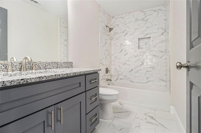 bathroom featuring marble finish flooring, toilet, bathing tub / shower combination, vanity, and baseboards