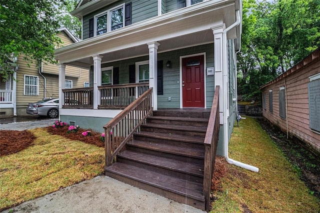 property entrance with a porch and a lawn
