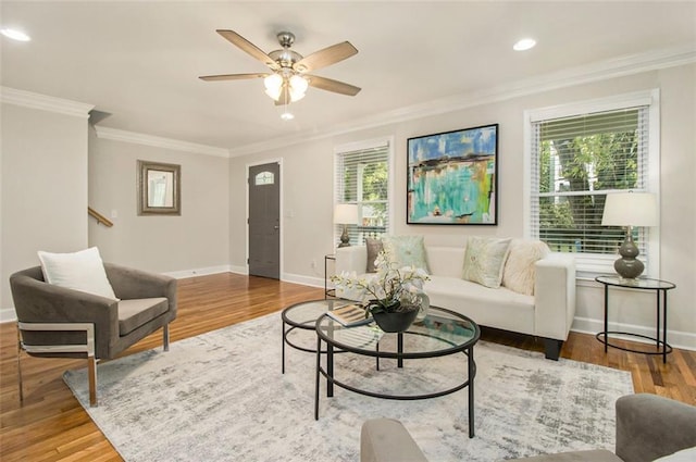 living area with wood finished floors, a ceiling fan, crown molding, baseboards, and recessed lighting