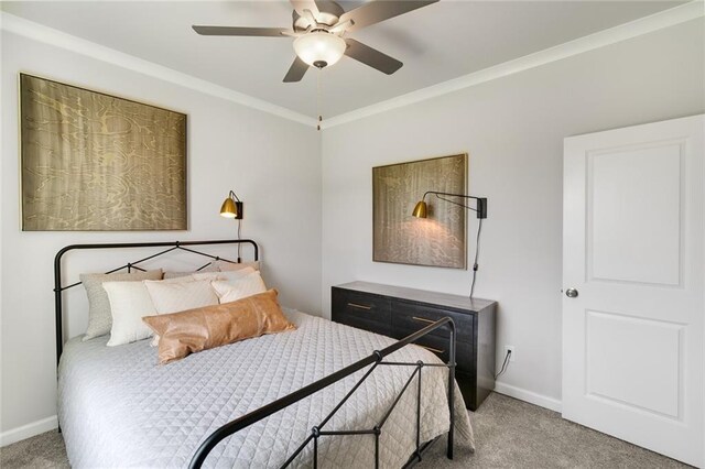 carpeted bedroom with ceiling fan and a raised ceiling