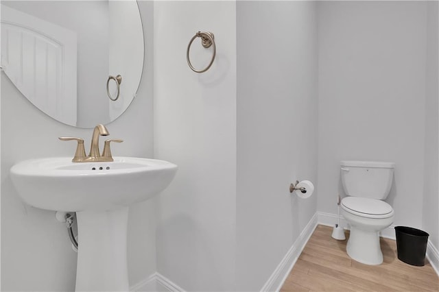 bathroom with hardwood / wood-style flooring, toilet, and sink