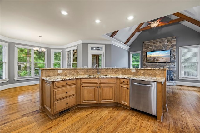 kitchen with stainless steel dishwasher, light wood-style flooring, a sink, a chandelier, and baseboards
