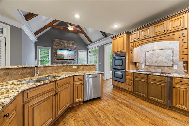 kitchen with black appliances, a sink, light wood-style flooring, a ceiling fan, and brown cabinets