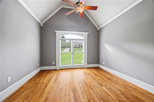empty room featuring a ceiling fan, ornamental molding, light wood-type flooring, baseboards, and lofted ceiling