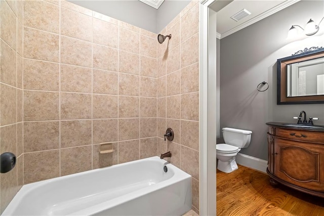 bathroom featuring toilet, shower / bathtub combination, wood finished floors, vanity, and ornamental molding