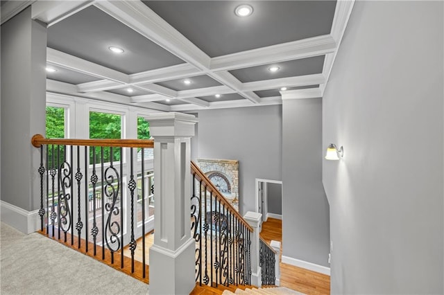 staircase with baseboards, beamed ceiling, coffered ceiling, recessed lighting, and wood finished floors