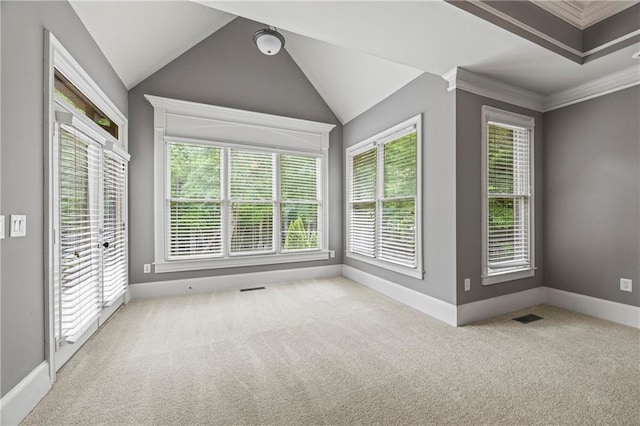 carpeted spare room with baseboards, lofted ceiling, and crown molding