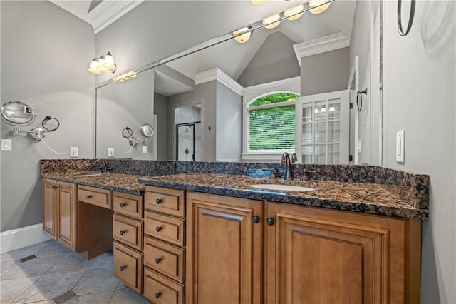 full bathroom featuring a stall shower, ornamental molding, double vanity, vaulted ceiling, and baseboards