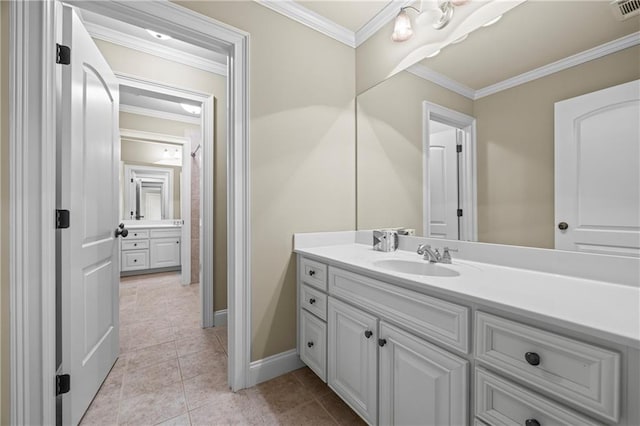bathroom featuring vanity, ornamental molding, tile patterned flooring, and baseboards