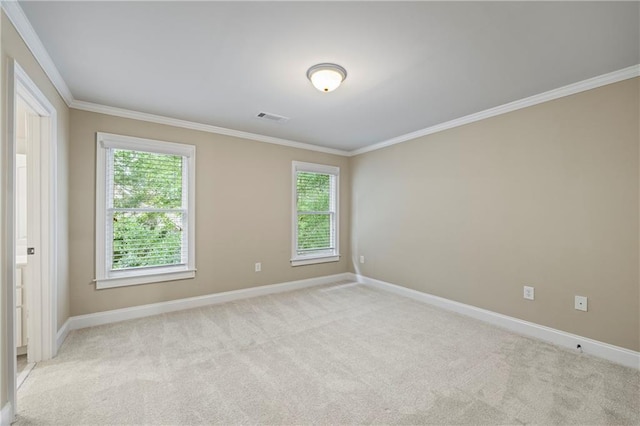 empty room featuring crown molding, baseboards, and light carpet