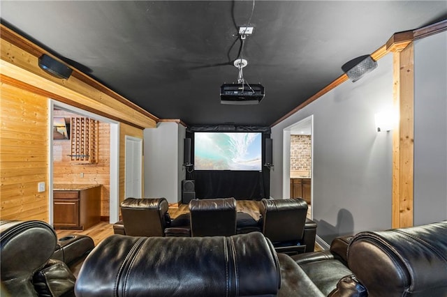 home theater room with wooden walls and ornamental molding