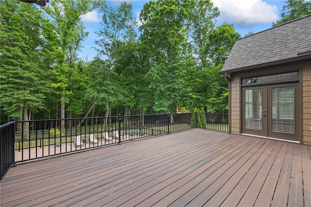 wooden deck with french doors and view of wooded area