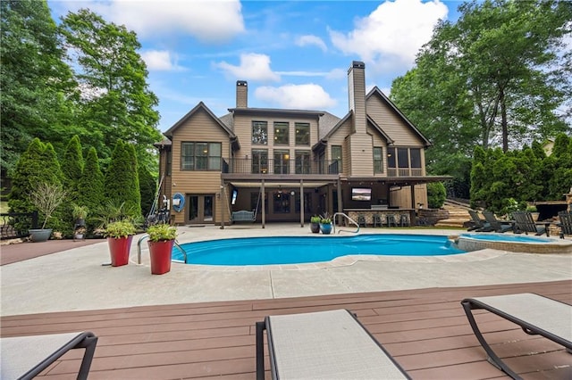 outdoor pool featuring a deck, french doors, and a patio area