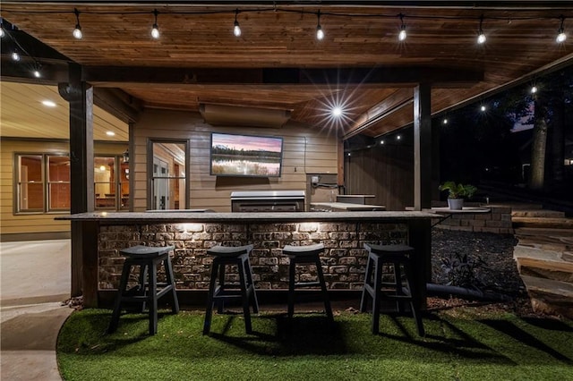 bar area featuring rail lighting and wood walls