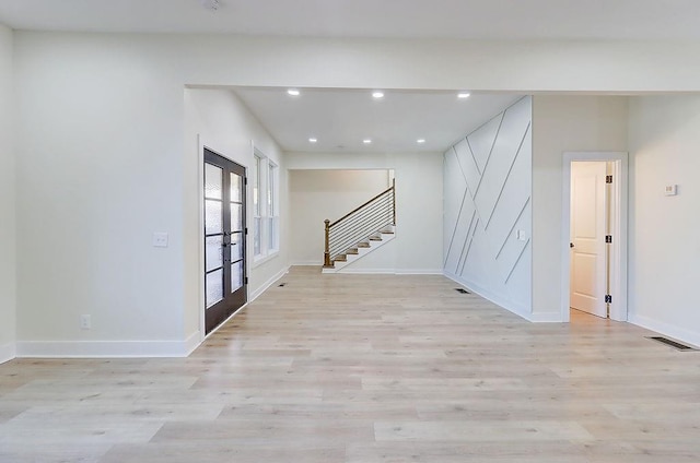 unfurnished room featuring recessed lighting, baseboards, stairs, light wood-style floors, and french doors