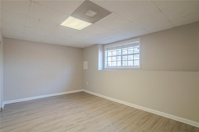 unfurnished room with a paneled ceiling and light hardwood / wood-style floors