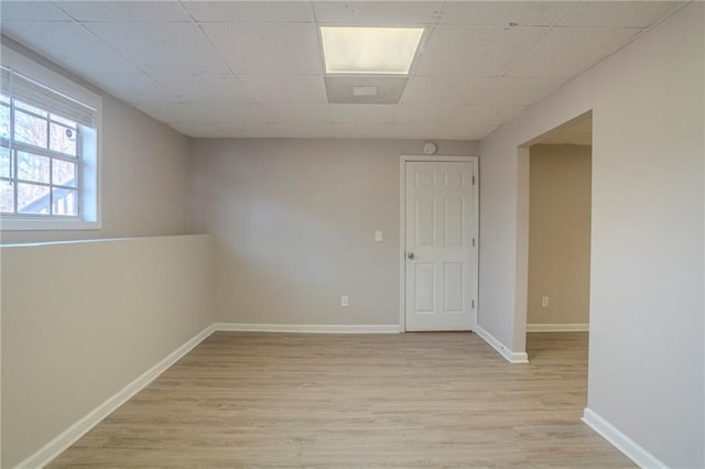 empty room featuring light hardwood / wood-style flooring and a paneled ceiling