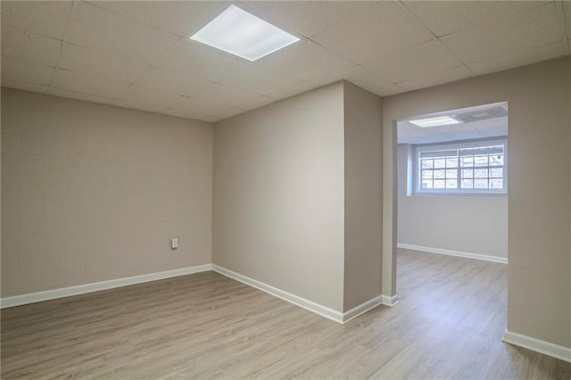 empty room with a paneled ceiling and light hardwood / wood-style flooring