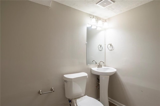 bathroom featuring toilet and a textured ceiling