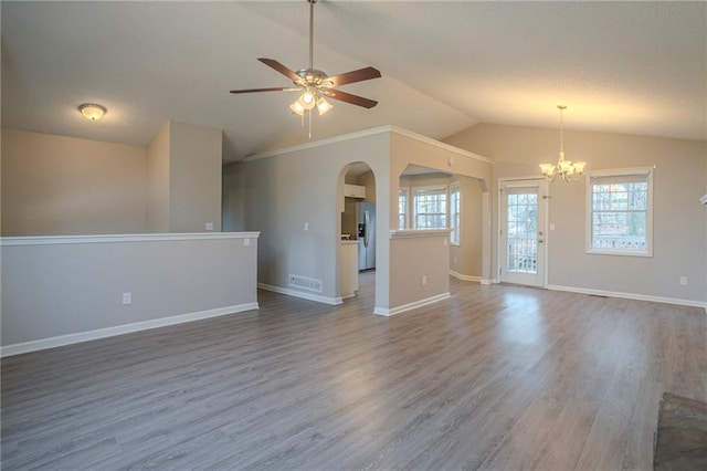 spare room with ceiling fan with notable chandelier, vaulted ceiling, and wood-type flooring