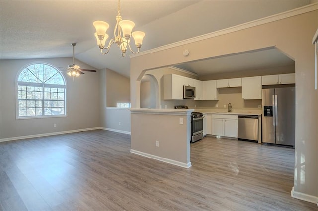 kitchen with pendant lighting, sink, white cabinets, stainless steel appliances, and light hardwood / wood-style flooring