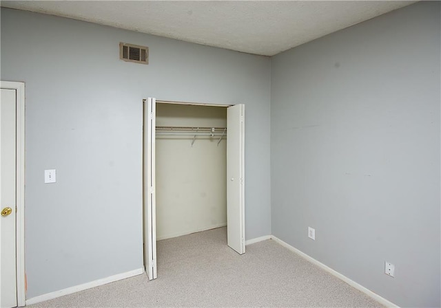 unfurnished bedroom with a closet and light carpet